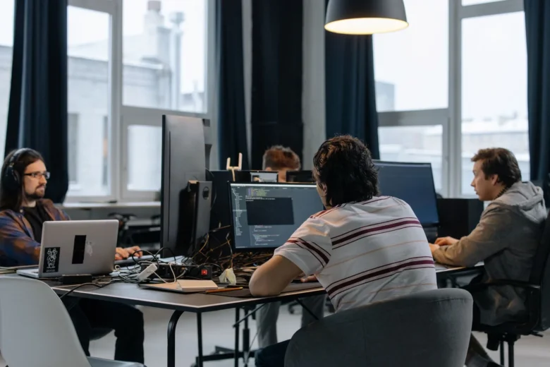 Equipe técnica analisando comparativo entre APIs corporativas de IA em monitores no escritório
