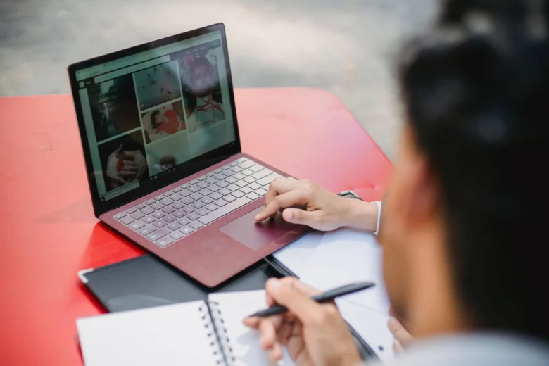 Profissional revisa em um notebook um texto rascunhado por assistente de IA antes de aproveitar o resultado no trabalho