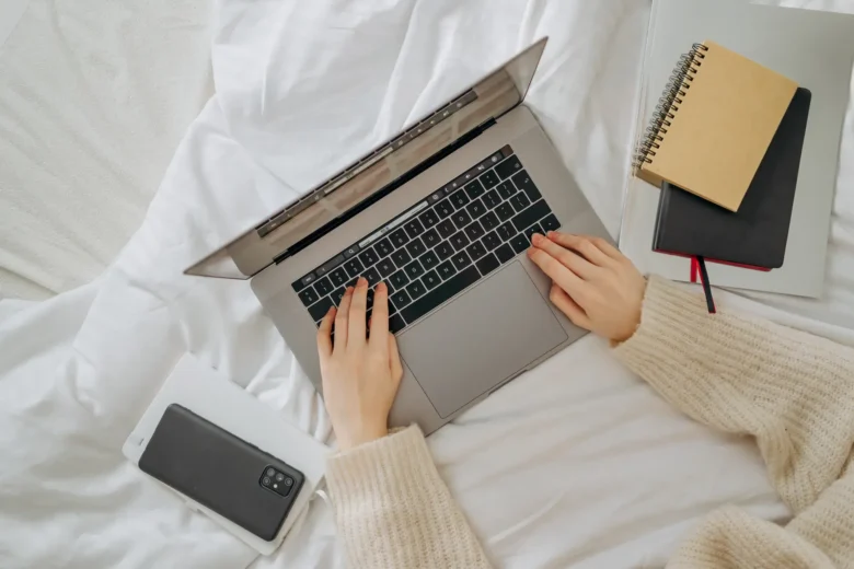Viajante usa um notebook para planejar um roteiro com apoio de IA, com mapa e passaporte sobre a mesa