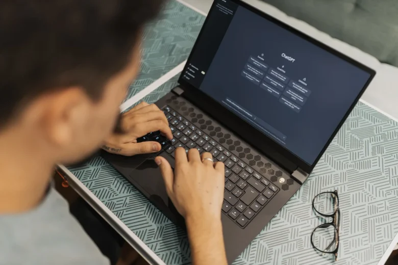 Pessoa digitando comandos em um assistente de IA no notebook durante o trabalho