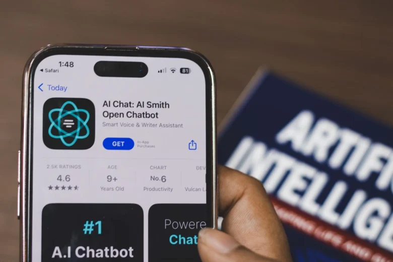 Pessoa consultando um assistente de IA no celular durante a rotina diária, com bloco de notas e xícara de café sobre a mesa