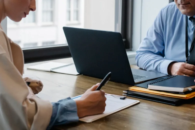 Profissional digitando em um notebook enquanto usa um assistente de IA no navegador para redigir documentos de trabalho
