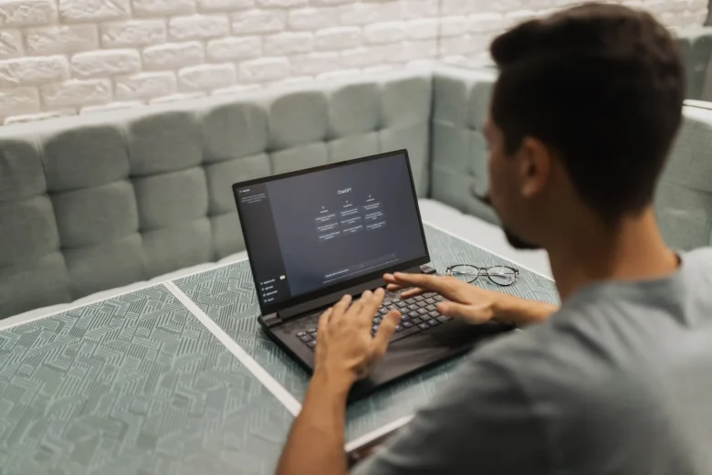 Profissional revisa em um laptop um texto gerado por assistente de IA em uma mesa de trabalho