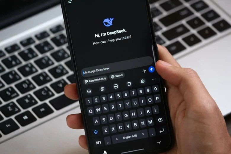Profissional digitando perguntas em um chatbot de IA aberto no notebook, com caderno de anotações ao lado para revisão das respostas