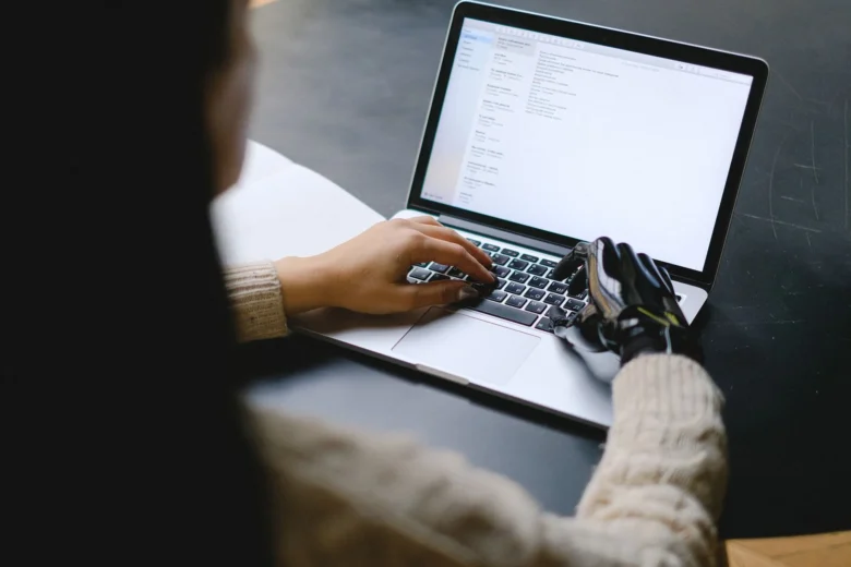 Profissional trabalhando em um notebook com assistente de inteligência artificial aberto ao lado, em uma mesa de escritório organizada