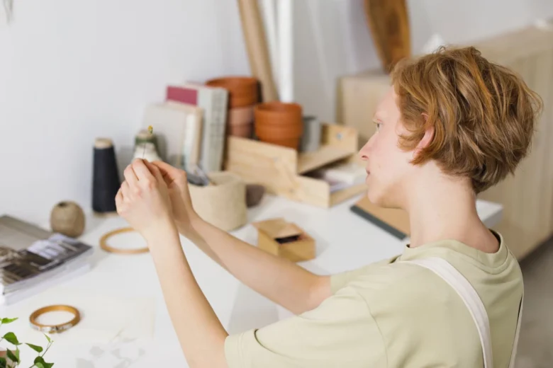 Mesa de trabalho doméstica com peças de artesanato manuais being preparadas para venda