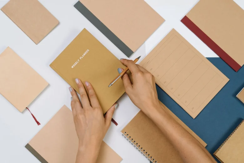 Caderno de planejamento semanal aberto na mesa, com caneta marcando os blocos da semana